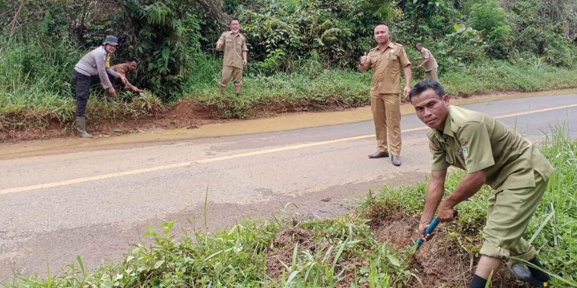Bhabinkamtibmas dan Perangkat Desa Buat Saluran Atasi Genangan Air di Jln Raya
